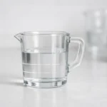 Verre doseur montrant 150 ml de liquide, illustrant simplement la conversion 150 ml en cl.