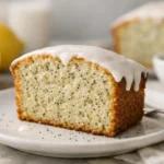 Recette de cake citron pavot facile, rapide et ultra moelleux. Une tranche dorée et parsemée de pavot avec glaçage citron.
